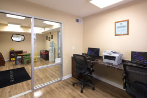 Business center with two chairs, two computers, printer, and children's play room